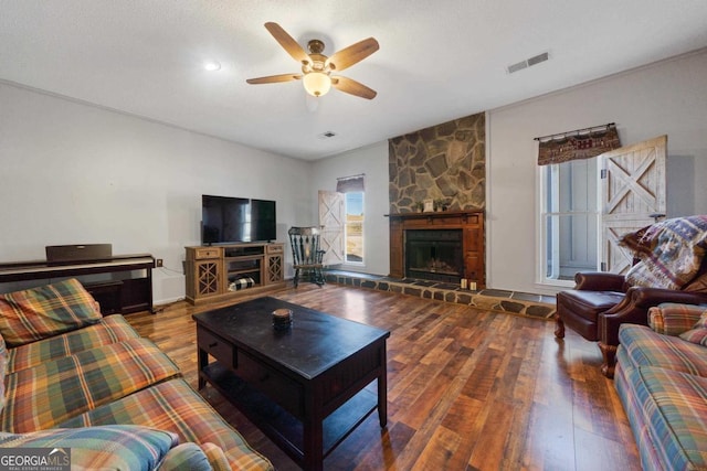 living room with ceiling fan, a fireplace, a textured ceiling, and hardwood / wood-style floors