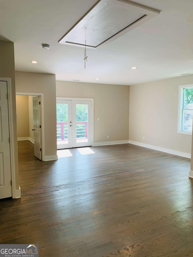 spare room featuring dark wood-type flooring, plenty of natural light, and french doors