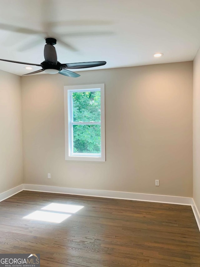 empty room featuring ceiling fan and dark wood-type flooring