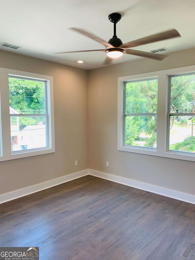 unfurnished room with ceiling fan, a wealth of natural light, and dark hardwood / wood-style floors