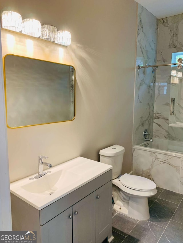 full bathroom featuring toilet, tiled shower / bath combo, and vanity