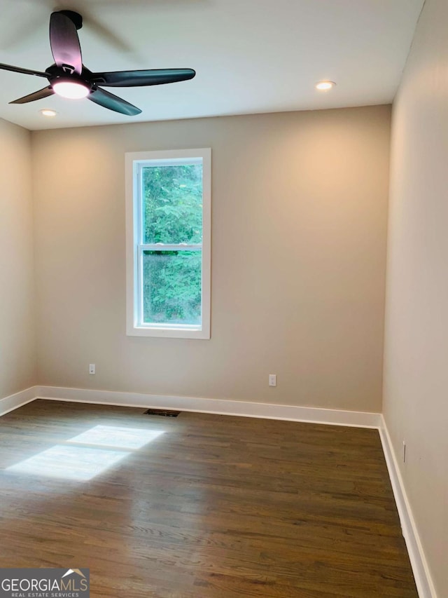 spare room with ceiling fan and dark hardwood / wood-style floors