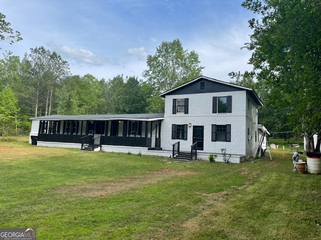 back of property with a yard and a sunroom