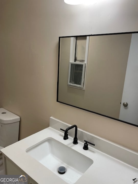 bathroom featuring toilet and vanity