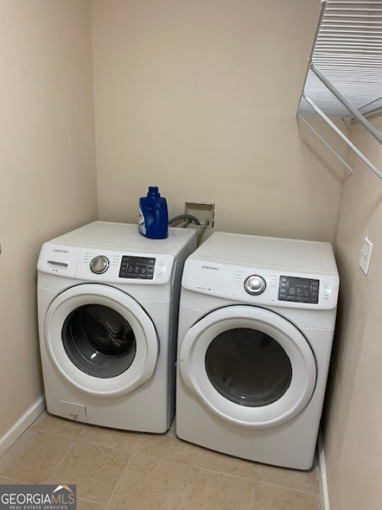 laundry room featuring separate washer and dryer and light tile patterned floors