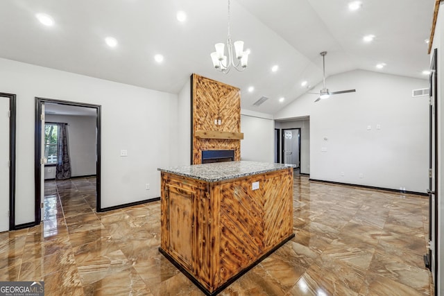 kitchen featuring a stone fireplace, stone counters, vaulted ceiling, a kitchen island, and pendant lighting