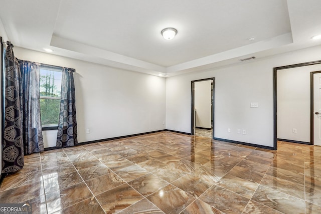 spare room with a raised ceiling