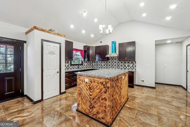 kitchen with decorative backsplash, lofted ceiling, wall chimney range hood, a kitchen island, and pendant lighting