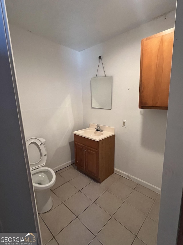 bathroom featuring toilet, tile patterned flooring, and vanity