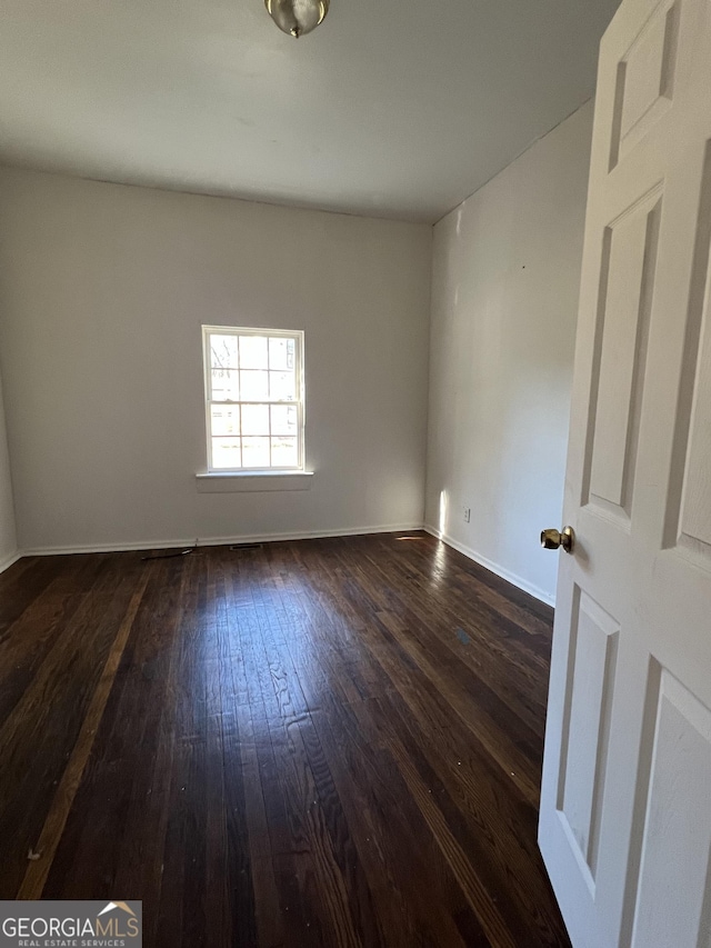 spare room with dark hardwood / wood-style floors