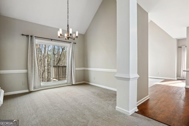 unfurnished dining area with baseboards, a notable chandelier, carpet floors, and lofted ceiling