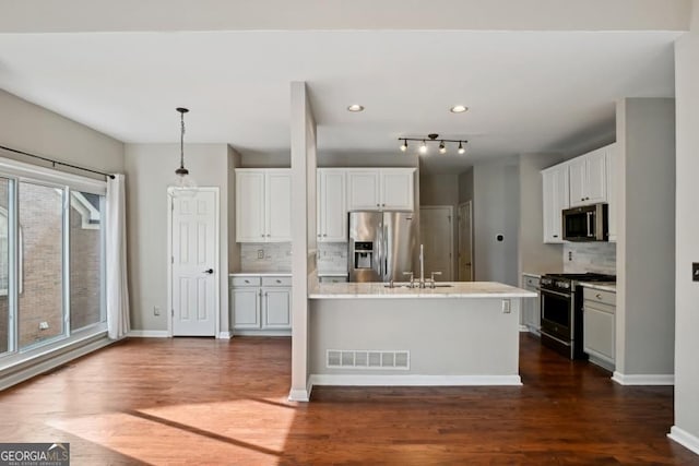 kitchen with decorative backsplash, dark wood-style flooring, white cabinets, and stainless steel appliances