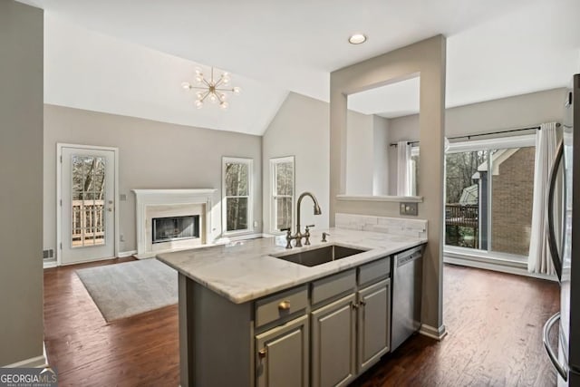 kitchen with a glass covered fireplace, dark wood-type flooring, a sink, dishwasher, and gray cabinetry