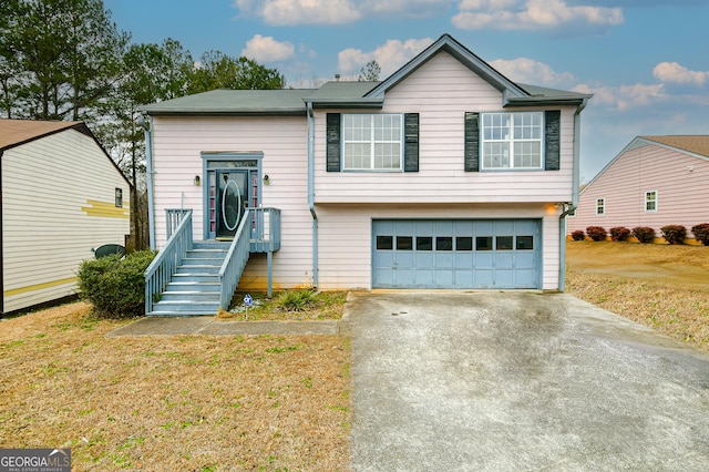 split foyer home with a garage and a front yard