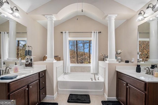 bathroom with decorative columns, vaulted ceiling, a washtub, and a healthy amount of sunlight