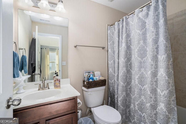 bathroom with toilet, walk in shower, and vanity