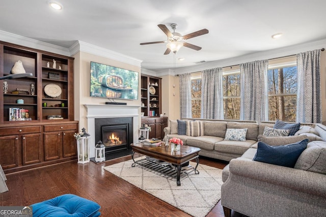 living room featuring ceiling fan, ornamental molding, and dark wood-type flooring