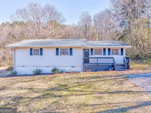 ranch-style home with a wooden deck and a front yard