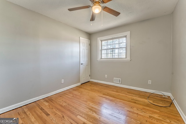 spare room with ceiling fan, light hardwood / wood-style floors, and a textured ceiling