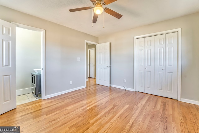 unfurnished bedroom with ceiling fan, a closet, and light wood-type flooring