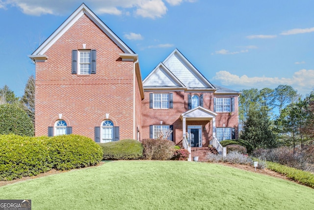 view of front of home featuring a front yard and brick siding