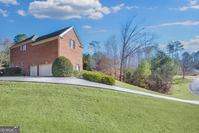 view of property exterior featuring a garage, brick siding, a lawn, and driveway