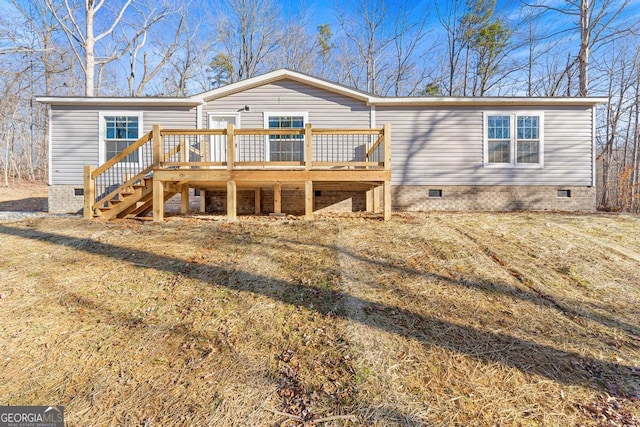 view of front of house with a deck and a front lawn