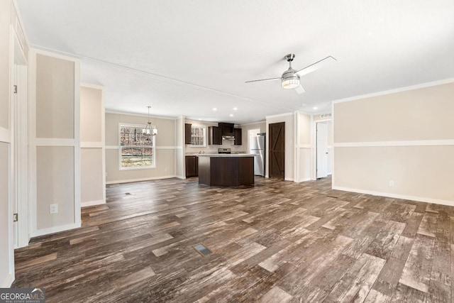 unfurnished living room featuring dark hardwood / wood-style flooring, crown molding, and ceiling fan with notable chandelier