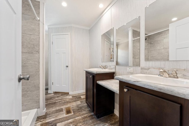 bathroom featuring ornamental molding, hardwood / wood-style floors, and vanity