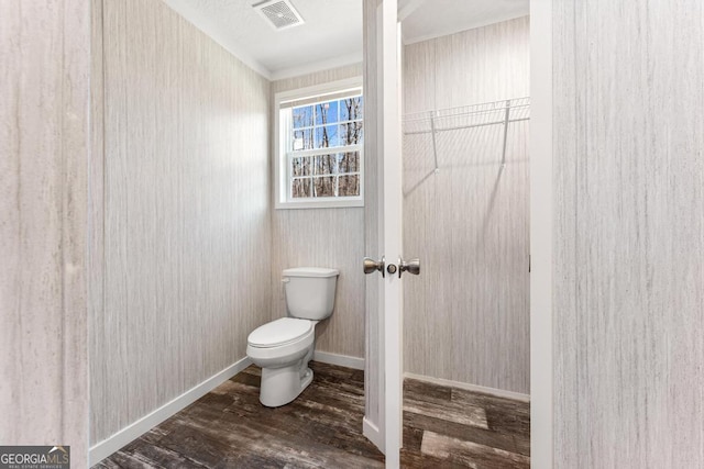 bathroom with toilet, wood-type flooring, and crown molding