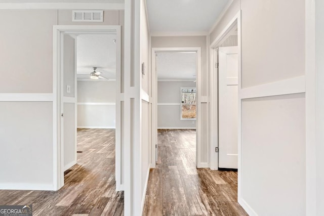 hall featuring dark wood-type flooring and ornamental molding