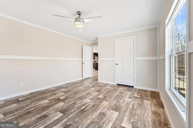 interior space featuring ceiling fan, ornamental molding, and wood-type flooring