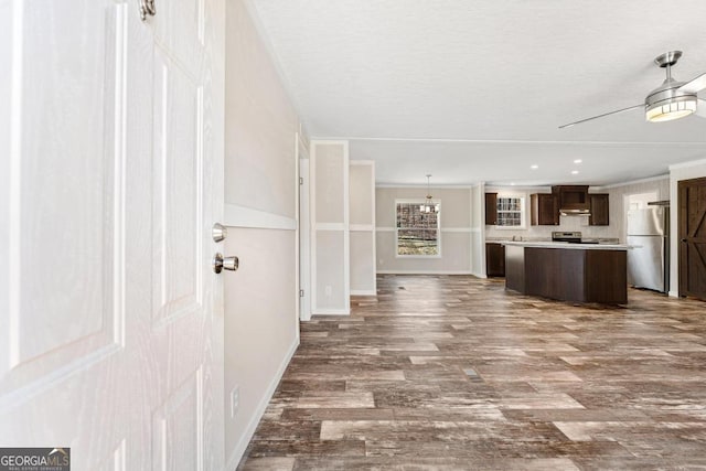 unfurnished living room featuring ceiling fan, ornamental molding, and hardwood / wood-style flooring