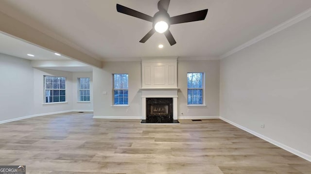 unfurnished living room with ceiling fan, a fireplace, ornamental molding, and light hardwood / wood-style flooring