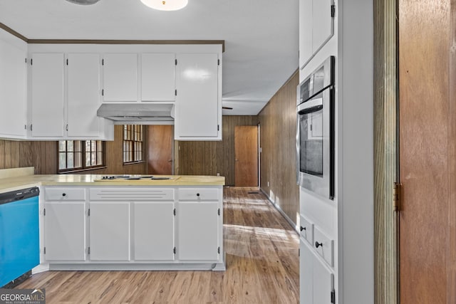 kitchen with white cabinets, wooden walls, dishwashing machine, and oven