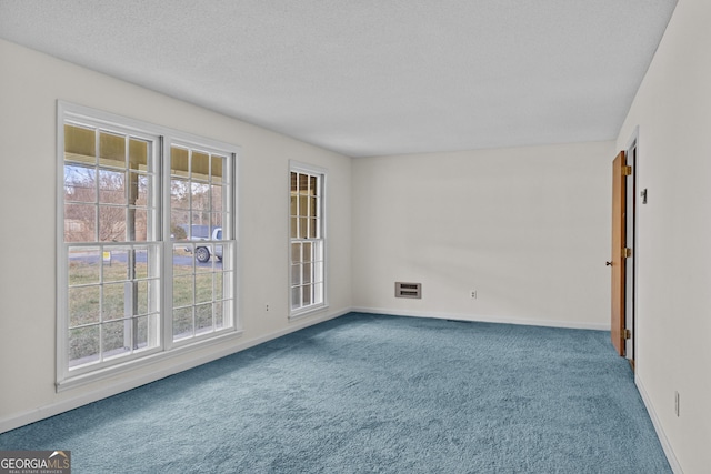 unfurnished room featuring carpet floors and a textured ceiling