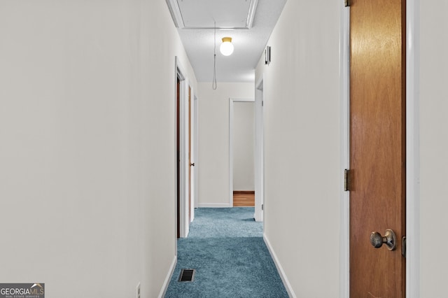 corridor with carpet and a textured ceiling