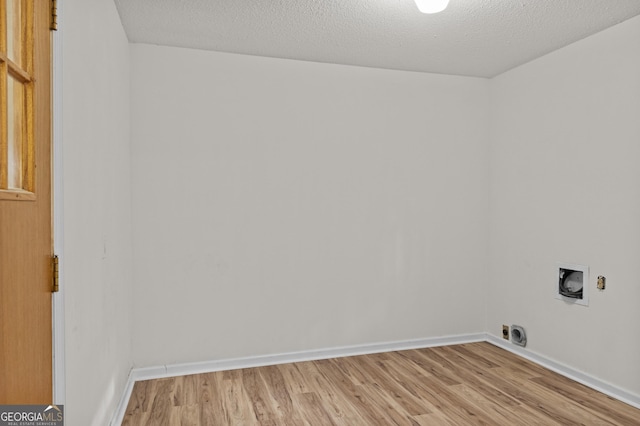 laundry area with hookup for a washing machine, a textured ceiling, and light hardwood / wood-style flooring