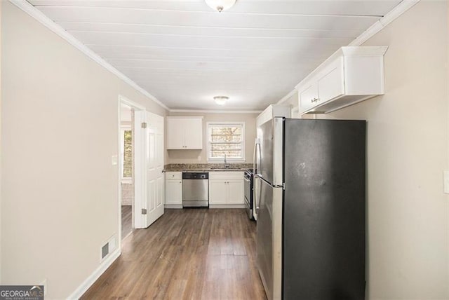 kitchen featuring white cabinets, appliances with stainless steel finishes, dark hardwood / wood-style floors, and crown molding