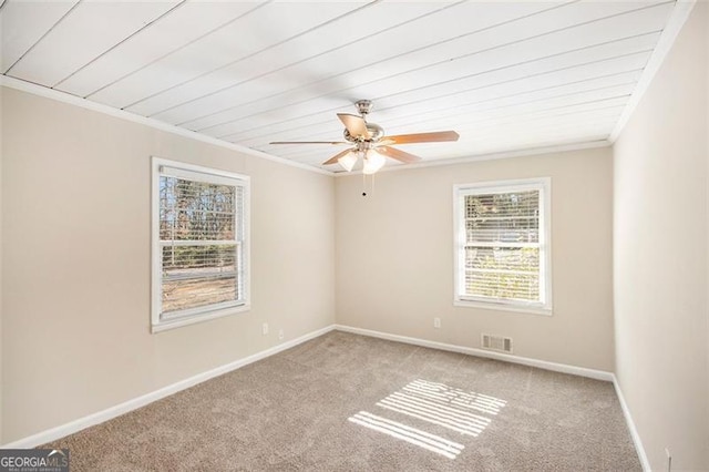 carpeted spare room with ceiling fan, crown molding, and wood ceiling