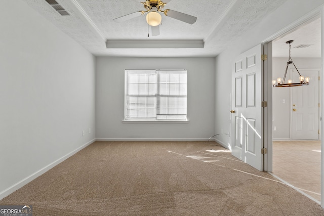 carpeted empty room with ceiling fan with notable chandelier, a tray ceiling, and a textured ceiling