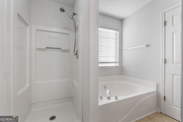 bathroom with a textured ceiling, independent shower and bath, and tile patterned flooring