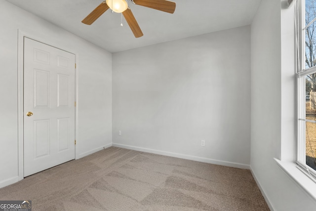 carpeted spare room featuring ceiling fan