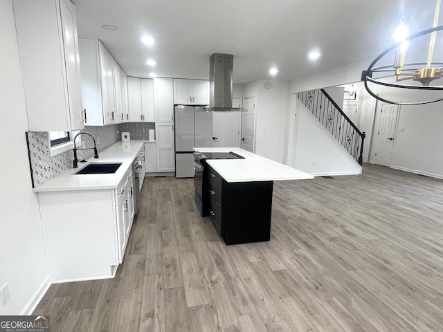 kitchen with black electric range oven, sink, white cabinetry, island range hood, and a kitchen island