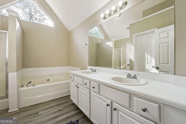 bathroom featuring independent shower and bath, lofted ceiling, hardwood / wood-style floors, and vanity