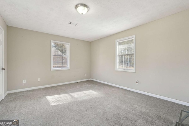 carpeted empty room with a textured ceiling