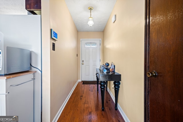 entryway with a textured ceiling and dark hardwood / wood-style flooring