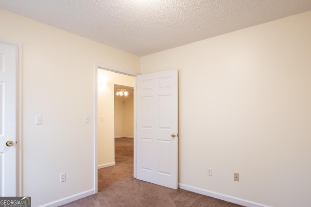 unfurnished bedroom featuring carpet and a textured ceiling