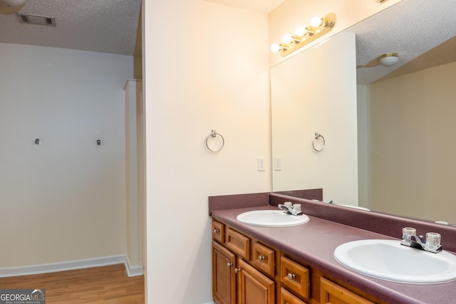 bathroom with vanity, a textured ceiling, and hardwood / wood-style flooring