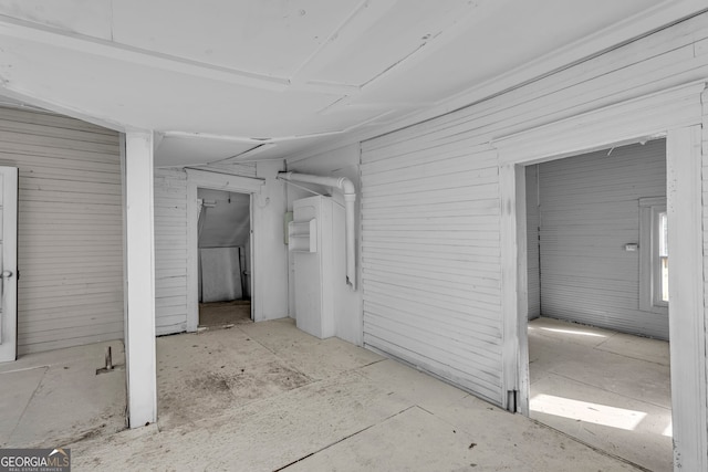 basement featuring wooden walls